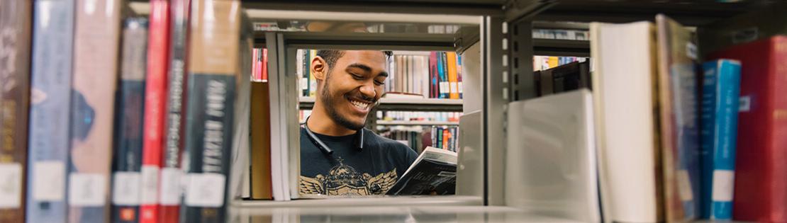 A student looks at a book in a Pima Library